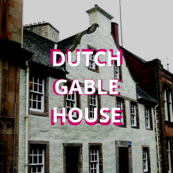 A white building with pink and white text in front of it: Dutch Gable House