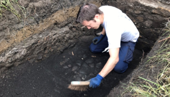 Person brushing something in a trench