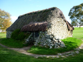Photo of a stone built cottage with a thatched roof