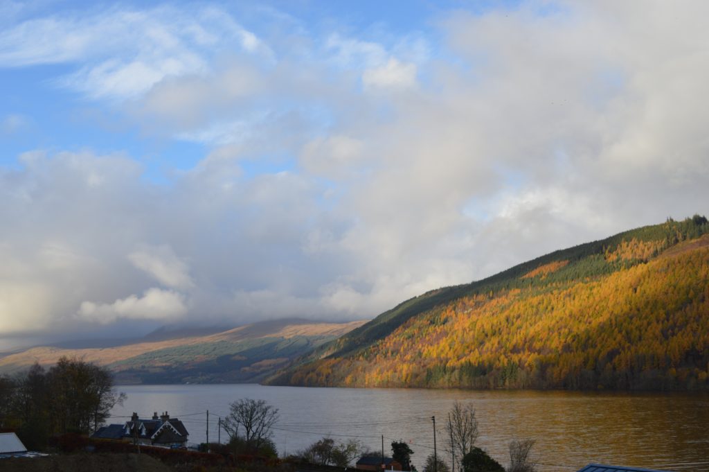 Photo of a loch with clouds above.