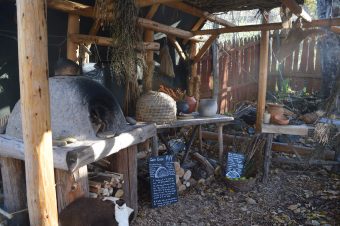 Photo of a round oven underneath a wooden tent.