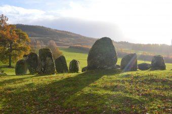 Photo of a standing stone circle in the sunlight.