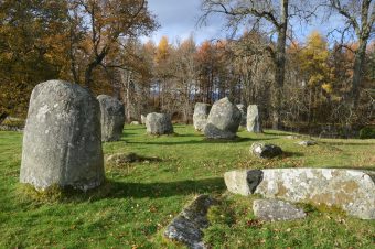 Photo of a group of standing stones in a sunny field.