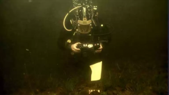 Photo taken underwater of a diver photographing artefacts.