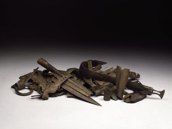 Photo of a pile of corroded weaponry and tools.