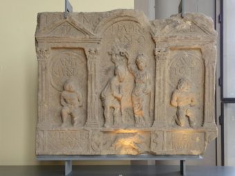 A slab a stone with carvings on it depicting captives and someone being celebrated