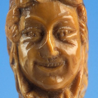 A face carved into a knife handle