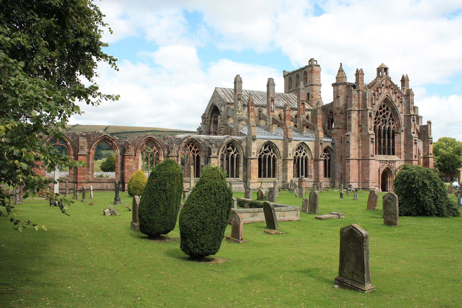 Photo of a red brick abbey with a graveyard in the foreground