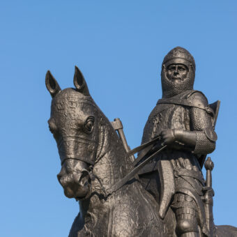 Photo of a statue of a man in medieval armour on an armoured horse