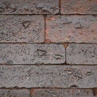 Three marks shaped like triangles on a brick wall