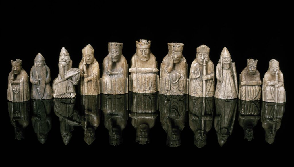 Almost all of the pieces in the collection are carved from walrus ivory, with a few made instead from whale teeth. The 79[15] chess pieces consist of eight kings, eight queens, 16 bishops, 15 knights, 13 rooks (after the 2019 discovery) and 19 pawns. The heights of the pawns range from 3.5 to 5.8 cm, while the other pieces are between 7 and 10.2 cm. Although there are 19 pawns (a complete set requires 16), they have the greatest range of sizes of all the pieces, which has suggested that the 79 chess pieces might belong to at least five sets.[16] All the pieces are sculptures of human figures, with the exception of the pawns, which are smaller, geometric shapes. The knights are mounted on rather diminutive horses and are shown holding spears and shields. The rooks are standing soldiers or "warders" holding shields and swords; four of the rooks are shown as wild-eyed berserkers biting their shields with battle fury.