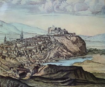 Engraving of a medieval castle atop a volcanic rock, with a loch on the right side below it, and a city sprawling out in front.