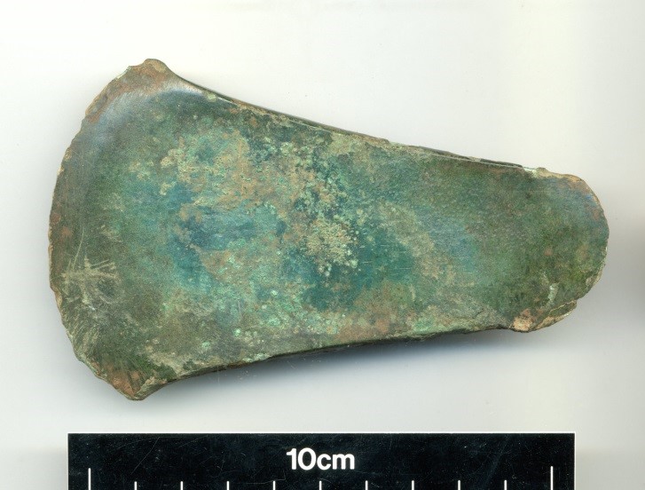 Photo of a green copper axe head.