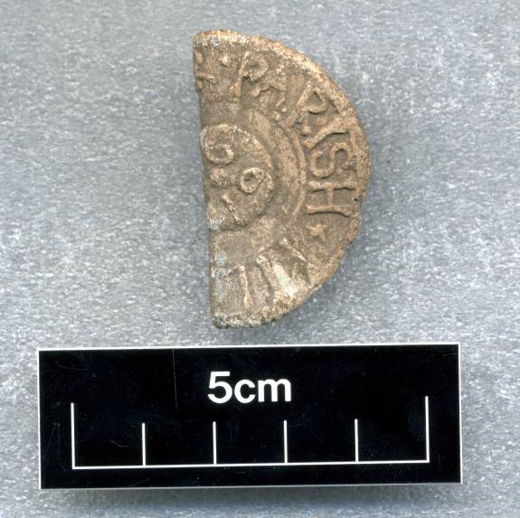 Photo of half of a sandy-coloured lead coin.