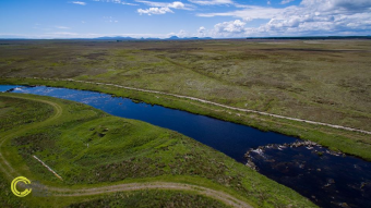 Aerial photo of a wide, blue river cutting through flat highland land.