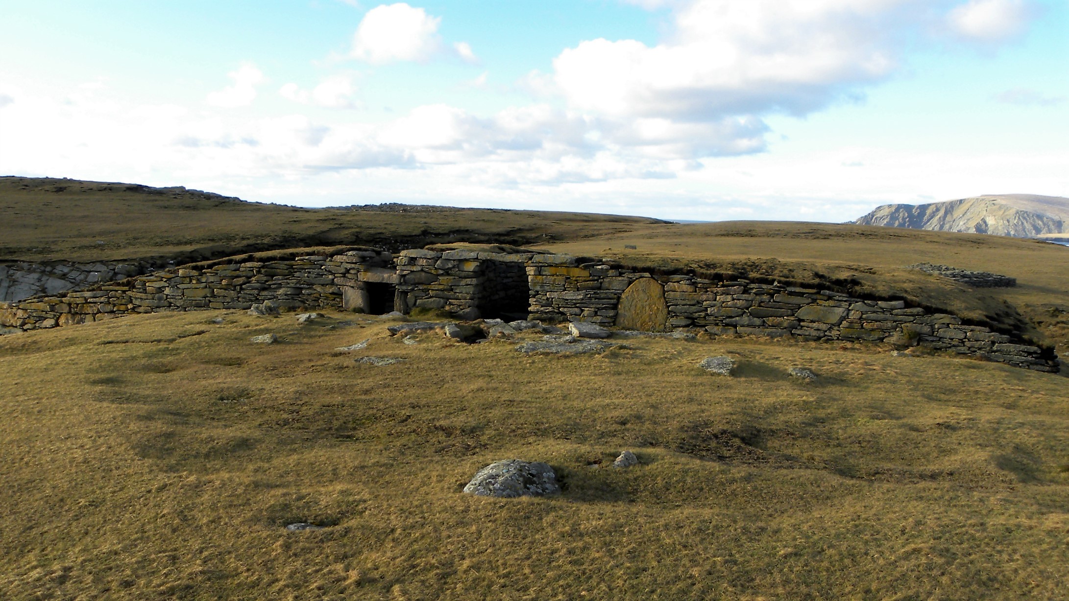 A stone structure covered in grass
