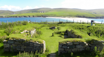 Ruins by the water buried by grass