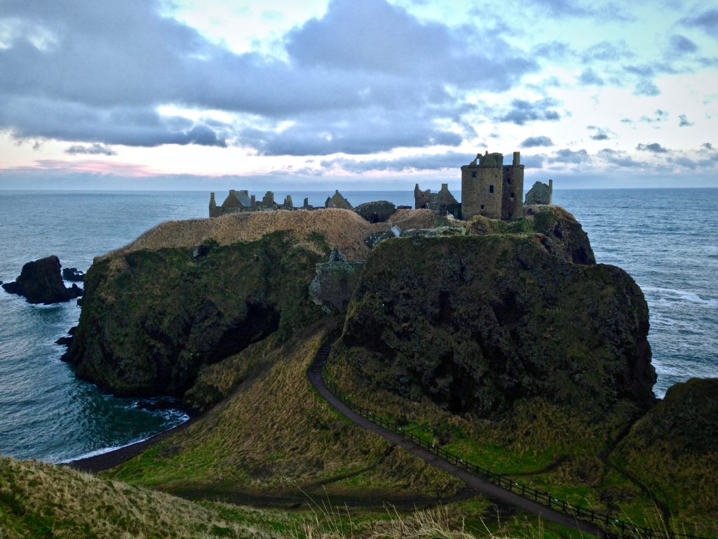 Photo of a castle on a cliff edge.