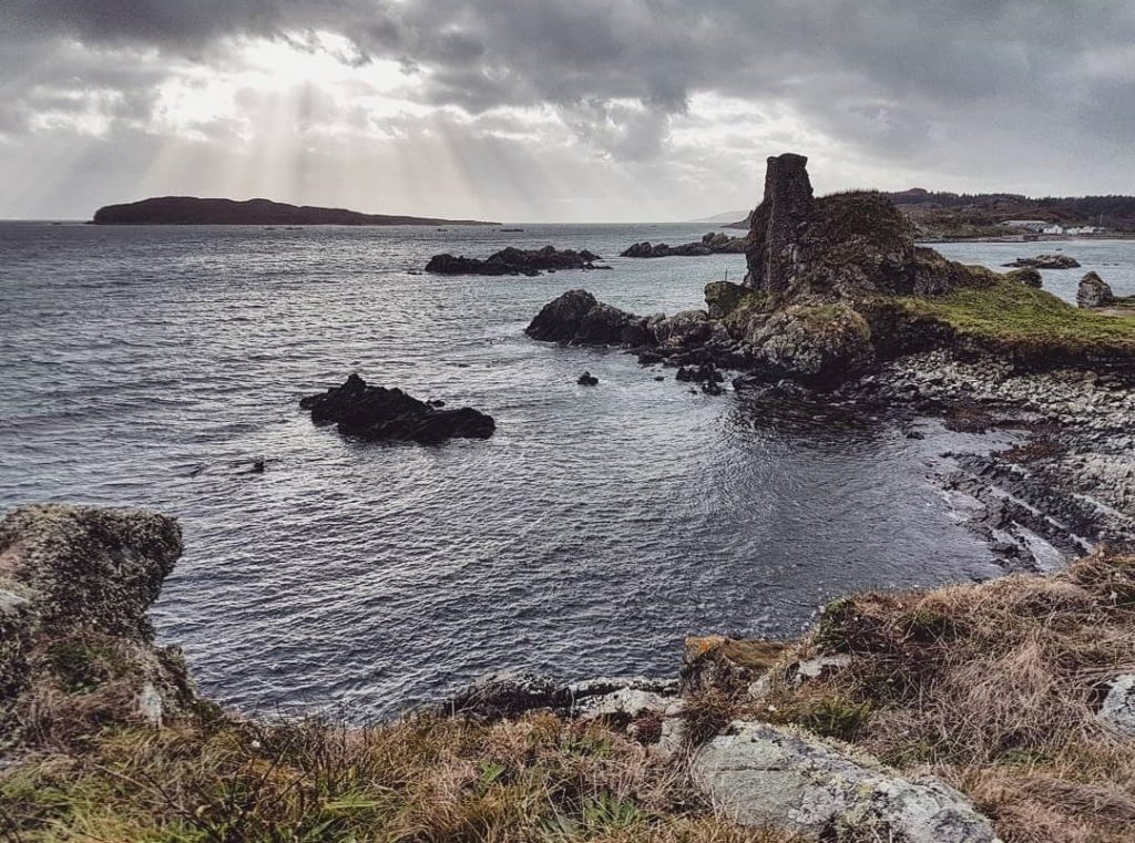 Photo of the ruins of a castle built in a bay on a cliff edge.