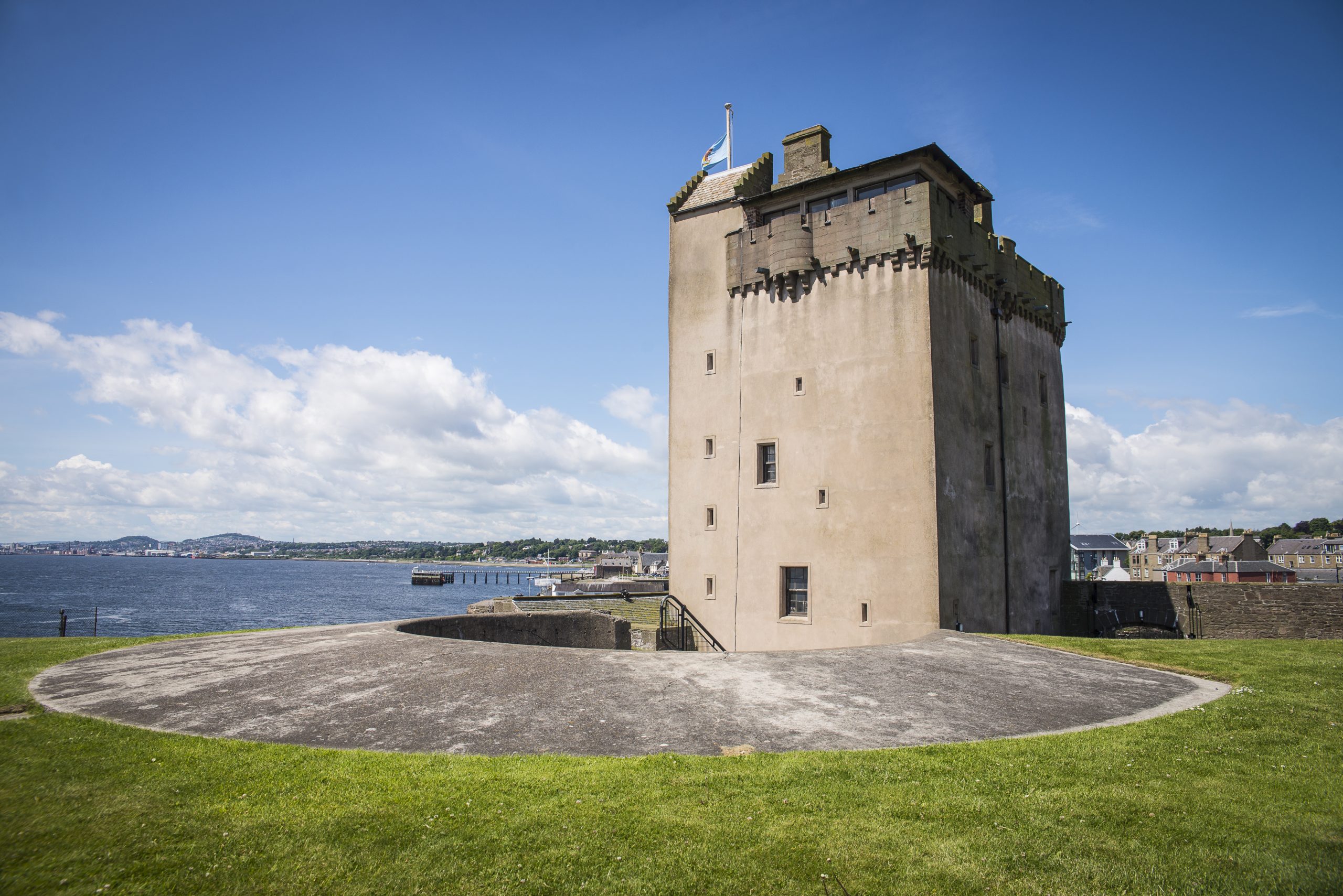 Photo of a square tower by the sea.