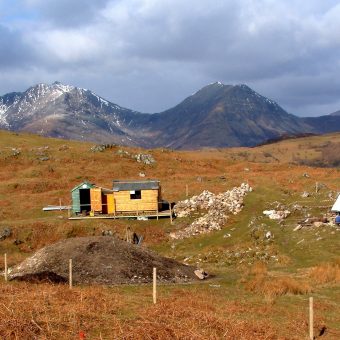 Photo of a beautiful burnt orange rural landscape with huge mountains in the background.