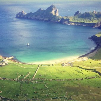 View over a bay with ruined stone buildings on land