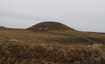 A large mound of earth covered in grass