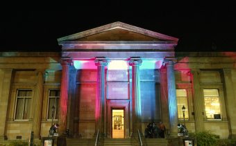 Photo of a stone museum with four columns at the entrance.