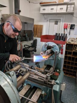 Photo of a person creating test tubes by glass blowing.