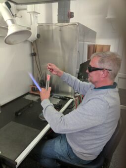 Photo of a person creating test tubes by glass blowing.