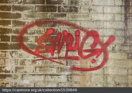 Red graffiti on a brick wall