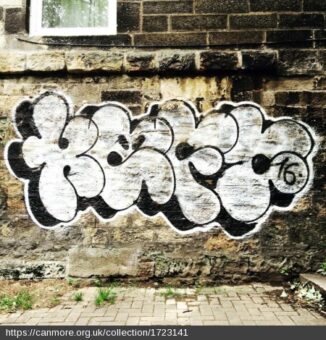 White and black graffiti on a brick wall