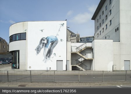 Graffiti on a building of a person being carried away by birds