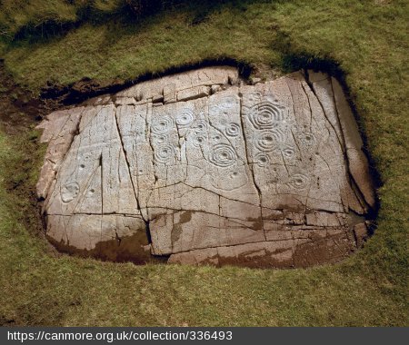Symbols carved into a large flat rock in the ground