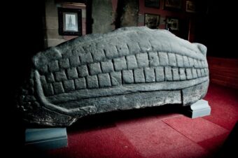 Photo of a large carved stone in the shape of an elongated tortoise shell