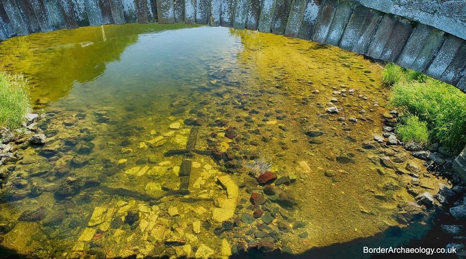 Photo of wooden planks underwater beneath a bridge