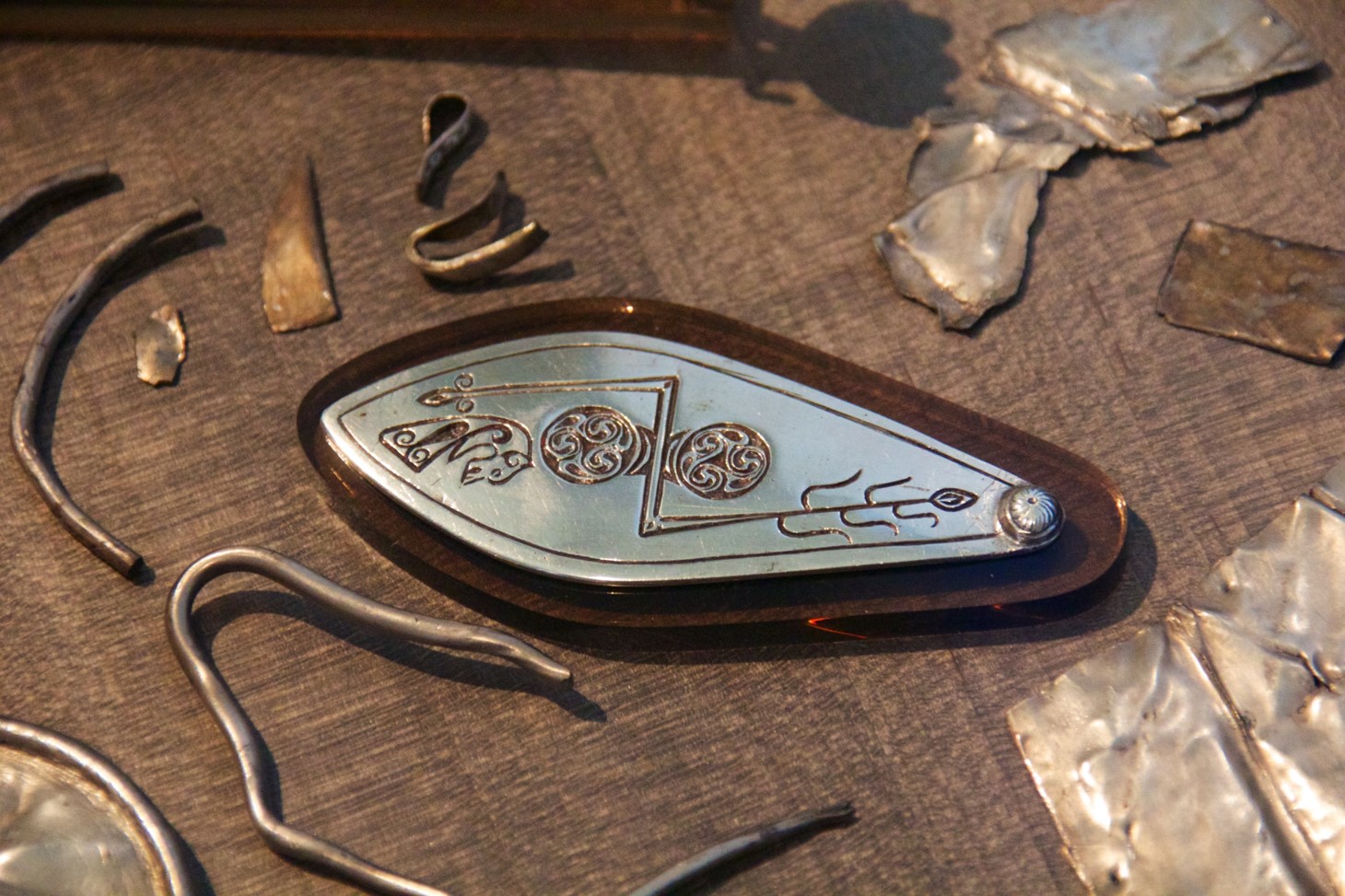 Photo of pieces of scrap and decorated silver in a museum case