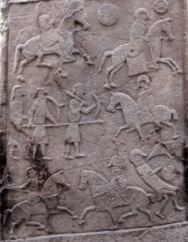 Photo of a carved stone depicting mounted warriors and archers in battle