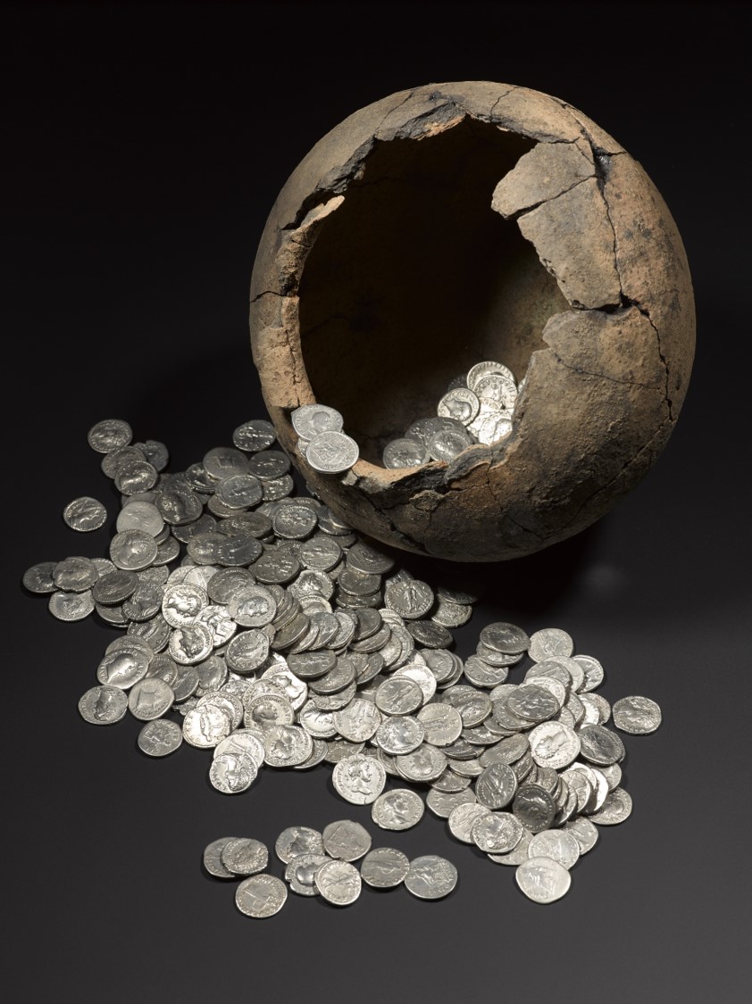 Photo of a broken bowl with silver coins spilling out onto a table