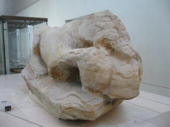 Photo of a large stone sculpture of a lioness eating a captive human