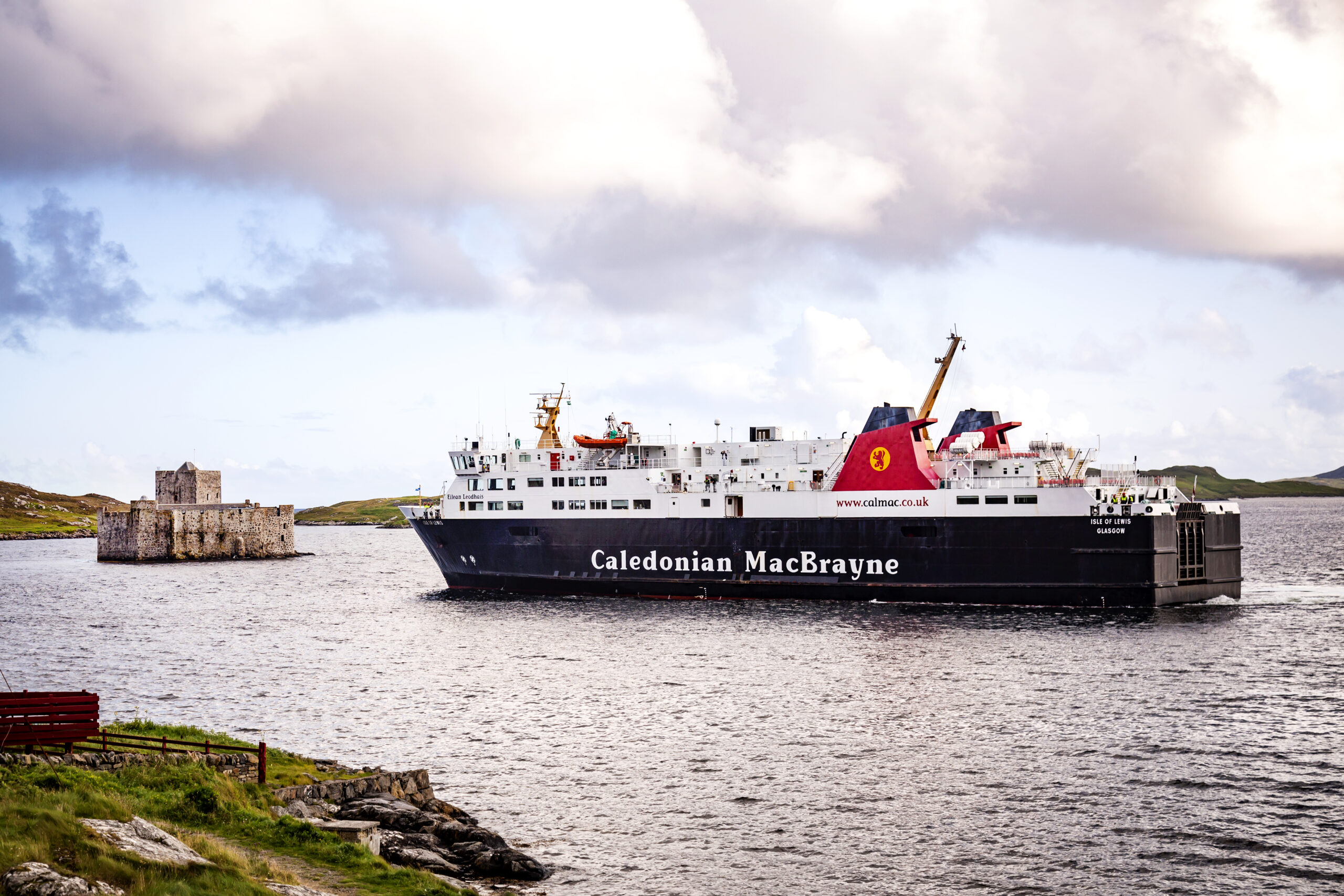 Photo of a ferry close to a castle in a loch
