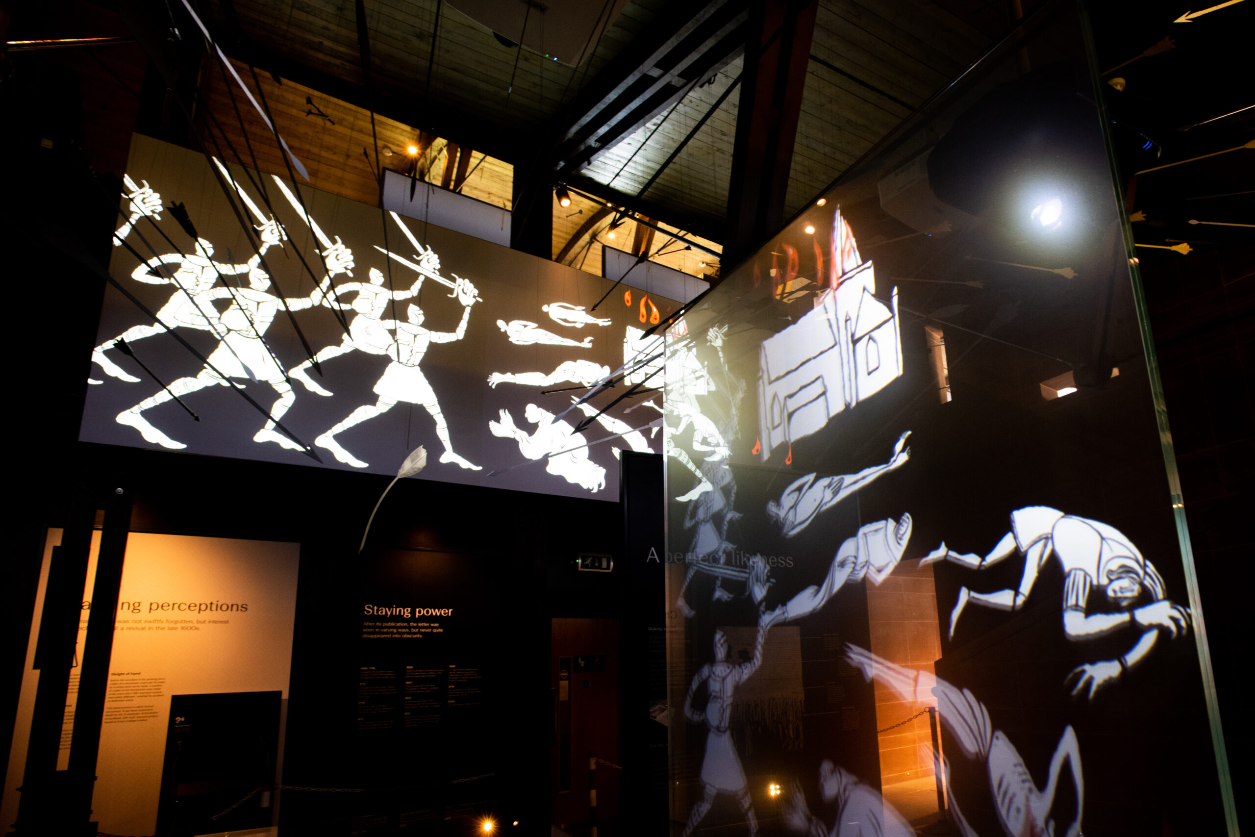 Photo of a museum exhibit with artwork of an army attacking monks
