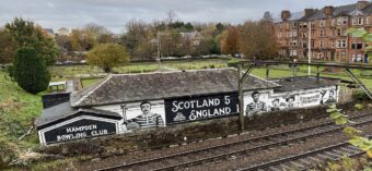 Photo of a bowling green with a mural painted on the hut commemorating a historic football win