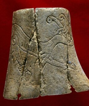 Photo of a carved bone featuring a deer-like animal