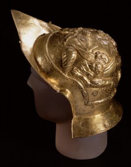 Photo of a pointed gold soldier's helmet with carved dome