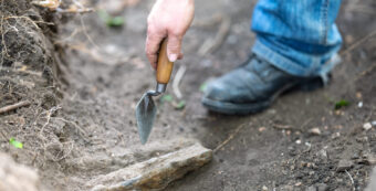 Person using a trowel in a trench