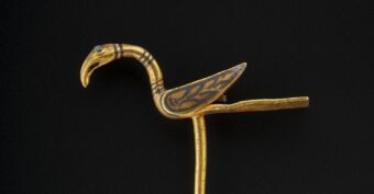 A gold pin in the shape of a bird