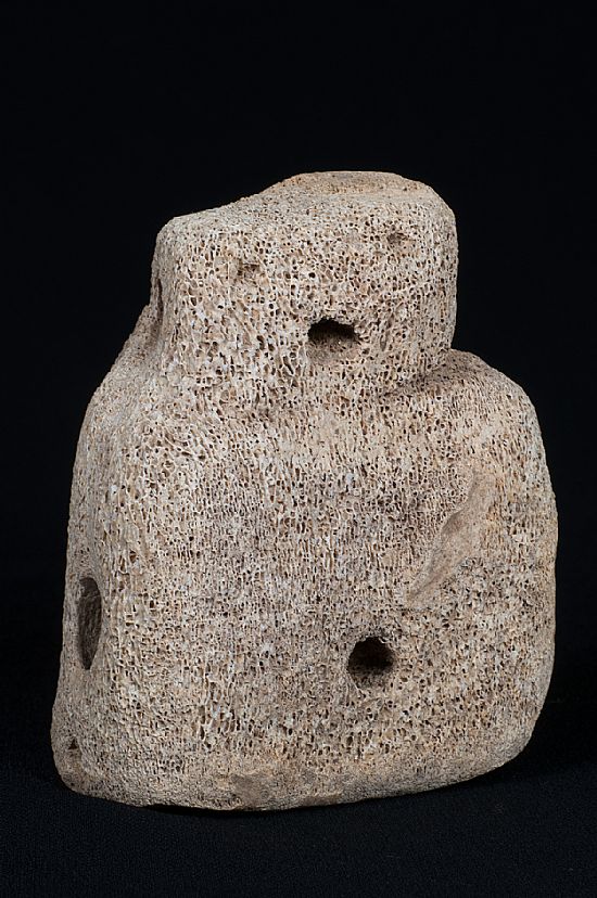 Whalebone figuring measuring 9.5cm high and 7.5cm wide, it had no arms or legs, and what appeared to be eyes, a mouth and a navel had been cut into the 'head' and 'body'. Two large holes running through the sides hinted that it may once have been suspended.