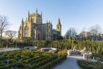 Photo of an abbey with a garden in the foreground