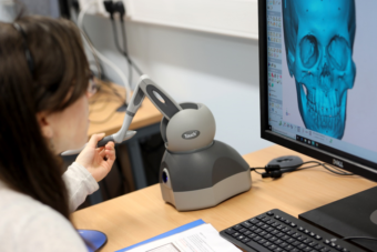 Photo of a person creating a facial reconstruction on a computer